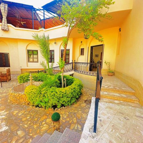 a house with a courtyard with a tree in it at El Nakhil Hotel in Luxor