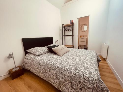 une chambre avec un lit et un miroir au mur dans l'établissement Le Trouville 165, à Trouville-sur-Mer