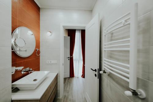 a bathroom with a white sink and a mirror at Luxury Inn Grand Residences in Tbilisi City