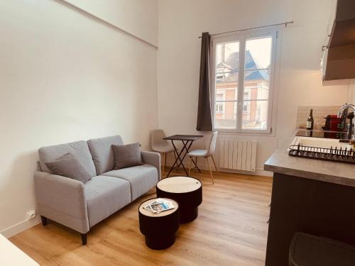 un salon avec un canapé et une table dans l'établissement Le Trouville 165, à Trouville-sur-Mer