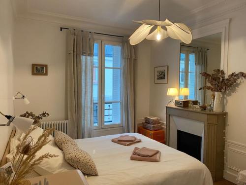 - une chambre avec un grand lit et une cheminée dans l'établissement Charmant Appartement Typique Parisien, à Paris