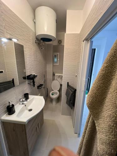 a bathroom with a sink and a toilet and a mirror at 50 Brooklyn suite in Taranto