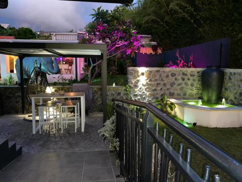a patio with a table and a fence at night at Hostal 170 Room 16 Service Appartement in Le Tampon