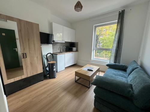 un salon avec un canapé et une table dans l'établissement Charmant studio palais des congrès Porte Maillot, à Levallois-Perret