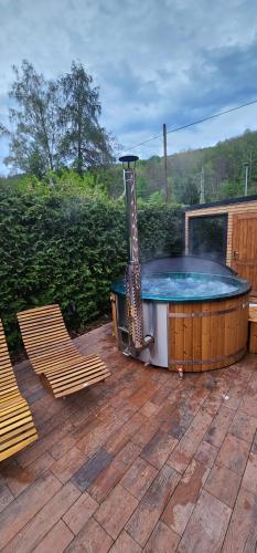 a hot tub on a patio with two chairs at Chalupa 246 in Vrchlabí
