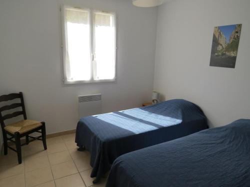 une chambre avec deux lits et une chaise et une fenêtre dans l'établissement Maison avec piscine dans le haut var, à Régusse