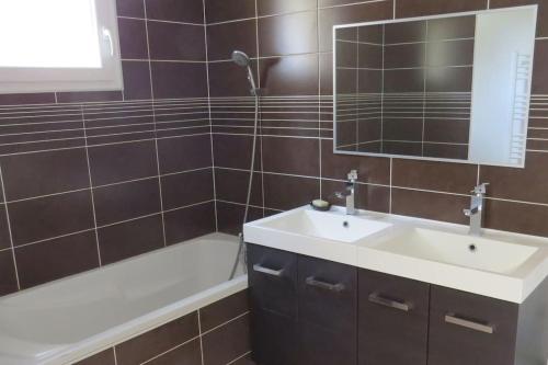 une salle de bain avec un lavabo, une baignoire et un miroir dans l'établissement Maison avec piscine dans le haut var, à Régusse