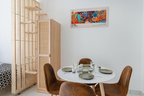 une salle à manger avec une table et des chaises blanches dans l'établissement Modern apartment next Arc de Triomphe, à Paris