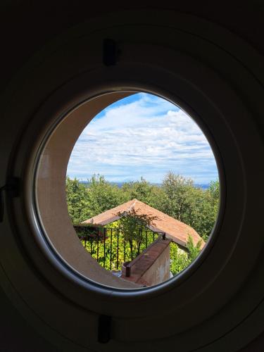 a round window with a view of a building at Casa Nonna Ada in Cisterna dʼAsti