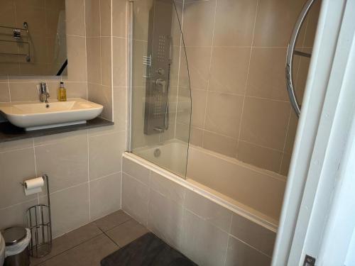 a bathroom with a tub and a sink and a shower at Flat 402 One bedroom apartment in Birmingham