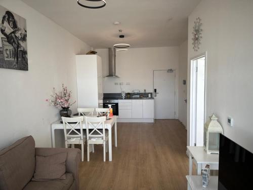 a living room and kitchen with a table and chairs at Flat 402 One bedroom apartment in Birmingham