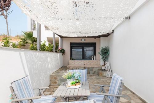 een patio met 2 stoelen en een tafel bij Sensi resort Nikiti in Nikiti