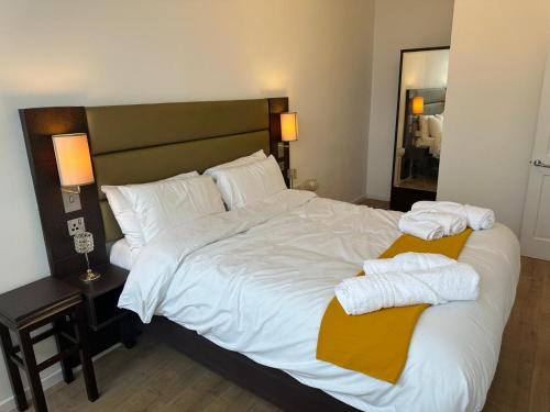 a bedroom with a large bed with towels on it at Flat 402 One bedroom apartment in Birmingham