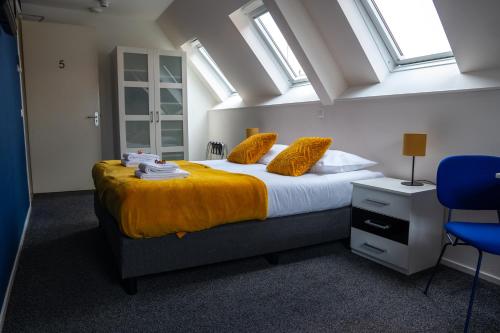 a bedroom with a bed with yellow sheets and windows at 1851 Bar - Hotel - Cinema in Wijk bij Duurstede