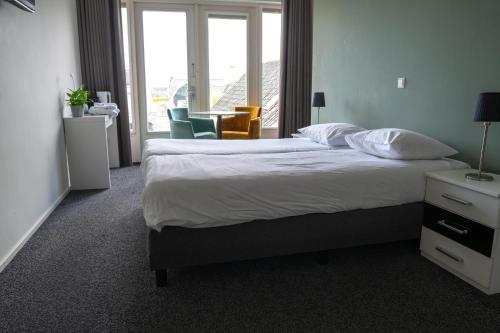 a hotel room with a bed and a table and chairs at 1851 Bar - Hotel - Cinema in Wijk bij Duurstede