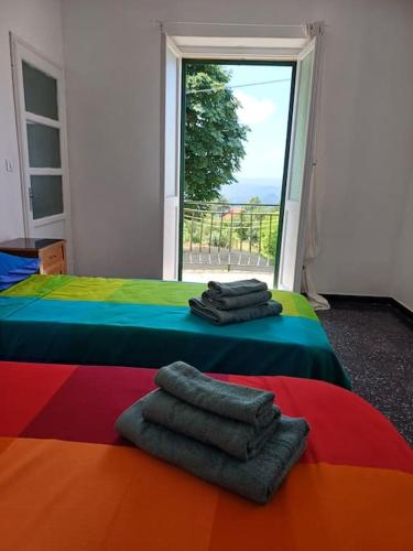 a bedroom with a rainbow bed with towels on it at Casa Mariuccia in Ponzone