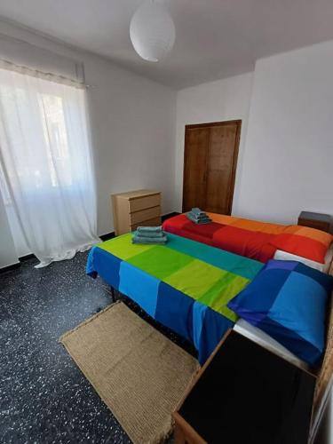 a bedroom with two beds with colorful sheets at Casa Mariuccia in Ponzone
