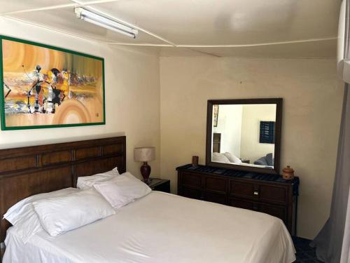 ein Schlafzimmer mit einem Bett und einem großen Spiegel in der Unterkunft My beautiful small house in Point E
