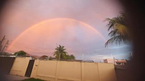 a large rainbow in the sky over a fence at Casa Rose Roraima · Casa em Boa Vista com piscina, ar condicionado in Boa Vista