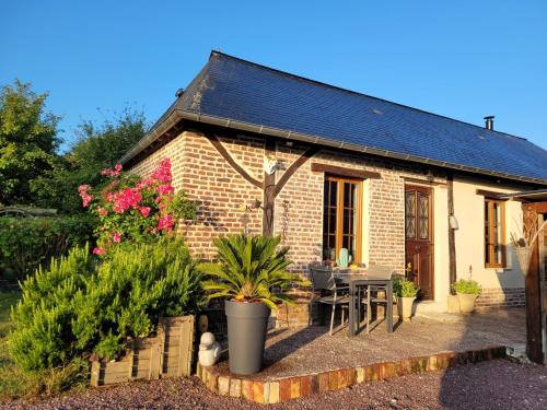 a small brick house with a table and chairs at Gîte à la campagne in Saint-Léger-du-Gennetey