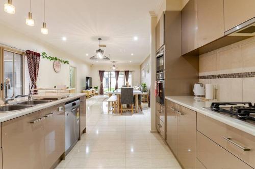 a large kitchen with stainless steel appliances and a dining room at Morden Elegant 4 Bedroom House in Broadview