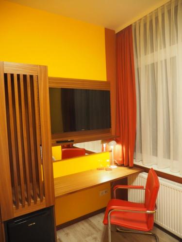 a room with a desk and a television and a chair at Gute Stuben in Frankfurt/Main