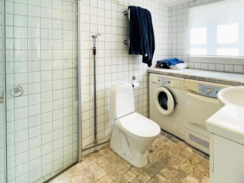 a bathroom with a toilet and a washing machine at 4 star holiday home in KYRKESUND in Kyrkesund
