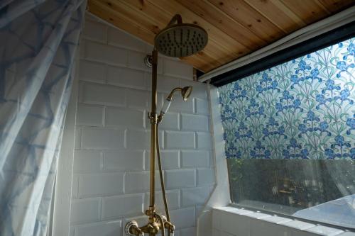 a shower in a bathroom next to a window at VamosBus in Sacca