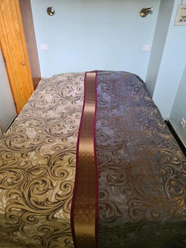 - un lit avec un couvre-lit brun à motifs et une ceinture brune dans l'établissement APT FRONT DE MER DANS RESIDENCE LUXE SECURISEE, à Banyuls-sur-Mer