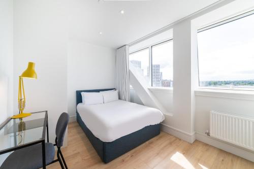a small bedroom with a bed and a window at Stylish Retreats on Olympic Way in London