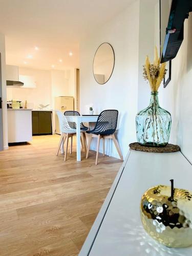 - un salon avec une table et un vase orné de fleurs dans l'établissement Le Chic Proche centre avec parking, à Grenoble