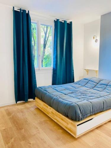 - une chambre avec un lit doté de rideaux bleus et d'une fenêtre dans l'établissement Le Chic Proche centre avec parking, à Grenoble