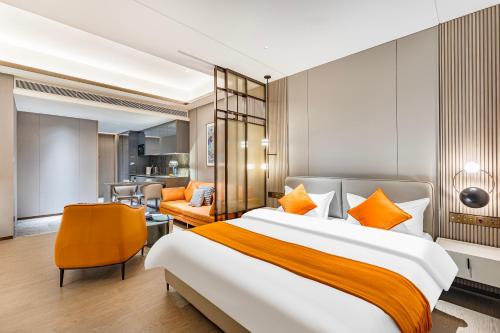 a bedroom with a large bed and a living room at BaiYue Apartment - Zhujiang New City Guangzhou in Guangzhou