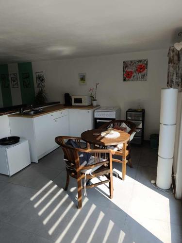 a kitchen with a table and chairs in a room at Terre Happy in Wibrin