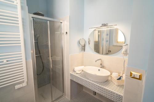 a bathroom with a sink and a mirror and a shower at Antica Loggia in Vibo Valentia