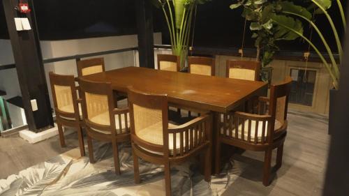 een houten tafel en stoelen op een balkon bij BAIA Laiya Marienella Resort in San Juan