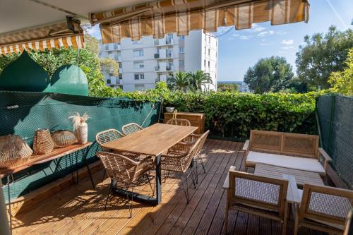 une terrasse en bois avec une table et des chaises en bois dans l'établissement Superbe 2 Pièces Rénové Grande Terrasse et Vue Mer, à Cagnes-sur-Mer