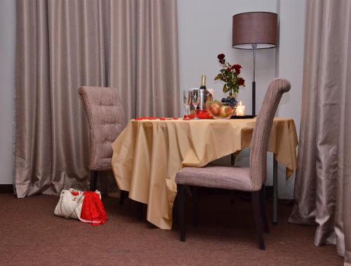 a dining room table with a table cloth and two chairs at Boutique Hotel Argo in Kutaisi