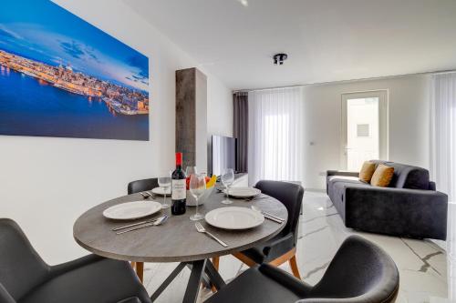 a living room with a table and chairs and a couch at Chic Apartment Stays in Il-Gżira