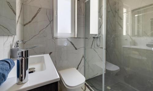 a bathroom with a shower and a toilet and a sink at Chic Apartment Stays in Il-Gżira