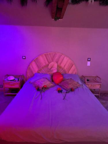 - une chambre violette avec un lit avec deux cœurs et des fleurs dans l'établissement jacuzzi exotique cinéma, à Sainte-Geneviève-des-Bois