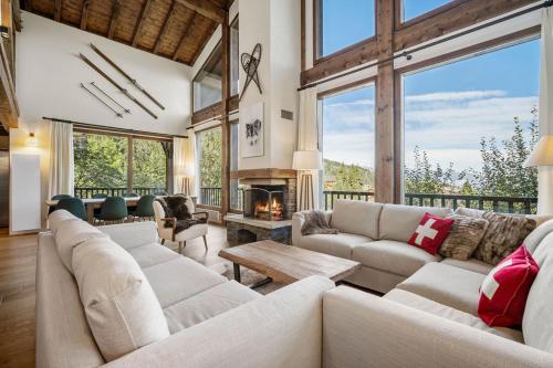 a living room with white furniture and a fireplace at 200m ski slopes - Chalet Manora - Courchevel La Tania in Courchevel