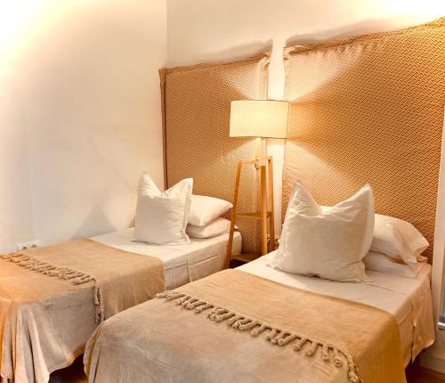 a hotel room with two beds with white pillows at Estudio Céntrico con Entrada Privada - Self Check-in HAZA ROYAL in Granada