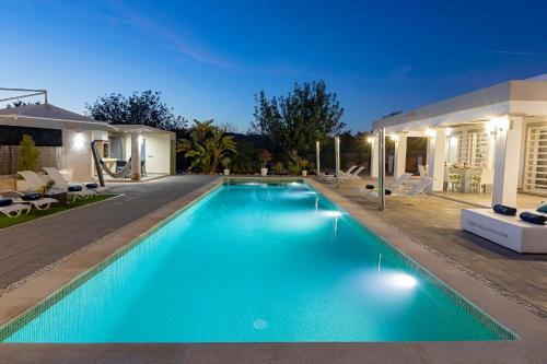 a swimming pool in the backyard of a house at Villa in San Antonio sleeps 10 in Ses Paisses