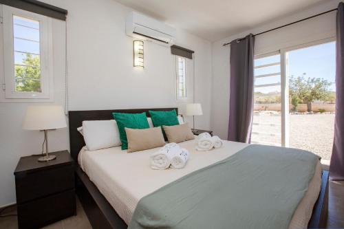a bedroom with a large bed with towels on it at Villa in San Antonio sleeps 10 in Ses Paisses