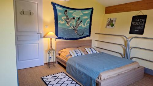 une chambre avec un lit et un tableau au mur dans l'établissement la villa de la fontaine, à Mondragon