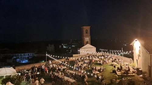 a crowd of people standing in front of a building with a clock tower at Casa Nonna Ada in Cisterna dʼAsti