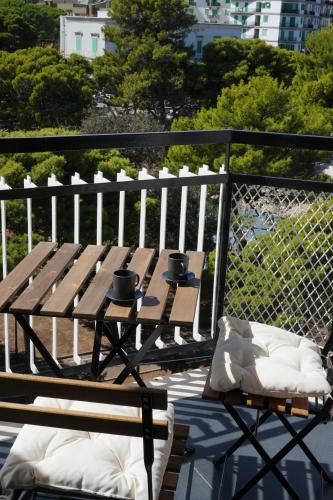 a wooden bench with two cups on top of it at BLUMI Apartment in Molfetta