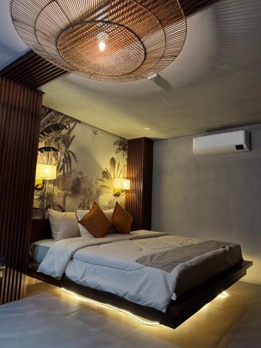 a bedroom with a large bed with a chandelier at BAIA Laiya Marienella Resort in San Juan