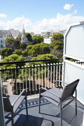 a balcony with two chairs and a view of a city at BLUMI Apartment in Molfetta